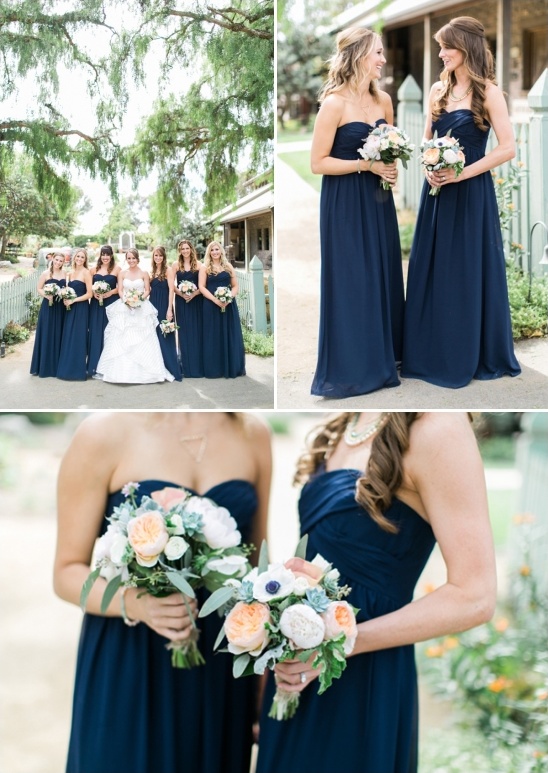 Bride with bridesmaids in navy blue dresses outdoors