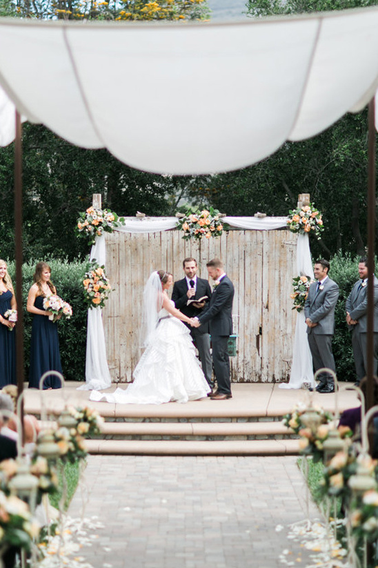 Bride and groom at outdoor wedding ceremony with decor