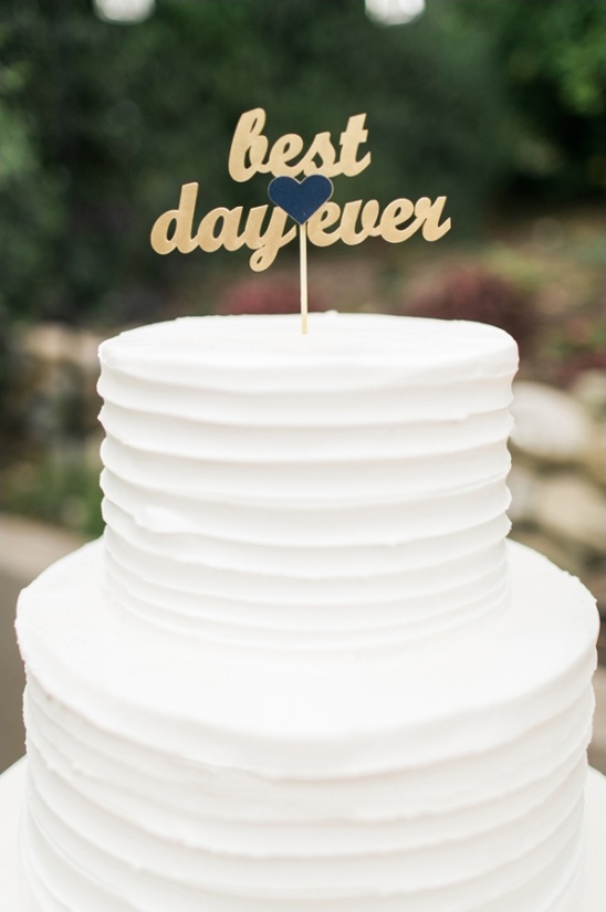 White wedding cake with best day ever topper