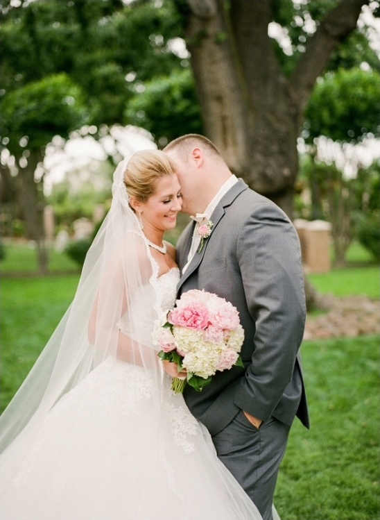 Bride smiles groom whispers sweet words wedding day