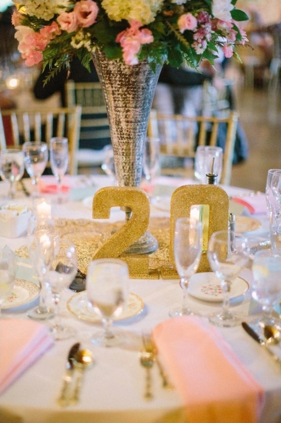 Elegant floral centerpiece and gold 20 on wedding table