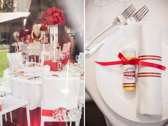 Wedding table setting red flowers white linens favors