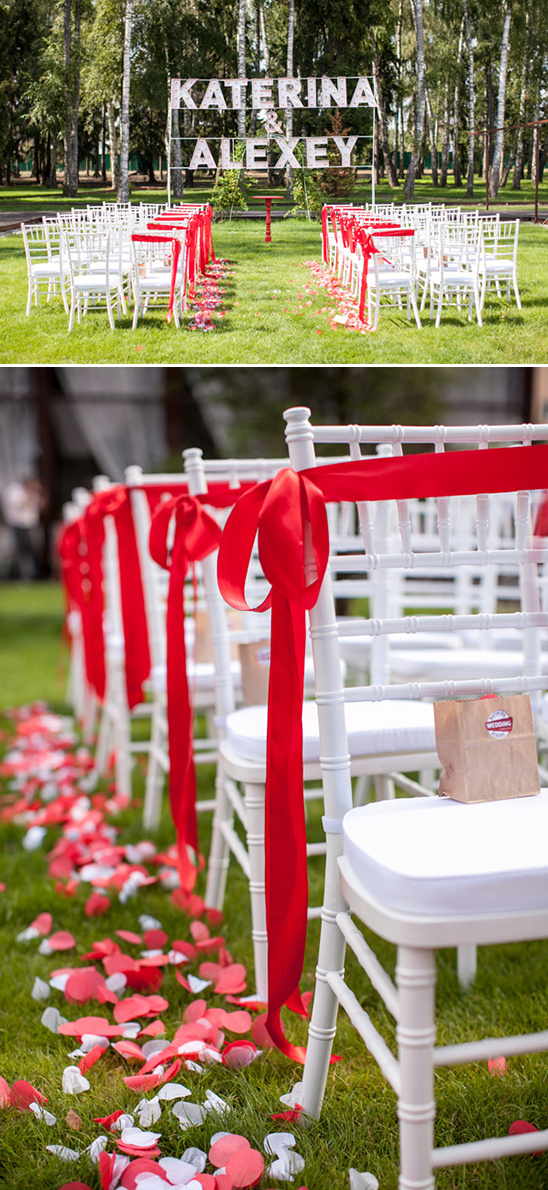 Outdoor wedding aisle white chairs red ribbons petals