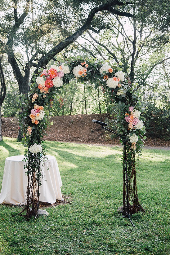 Floral wedding arch in garden setting for ceremony
