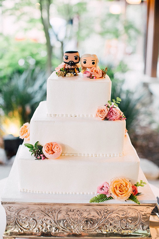 Three tier wedding cake topped with funko pop figures