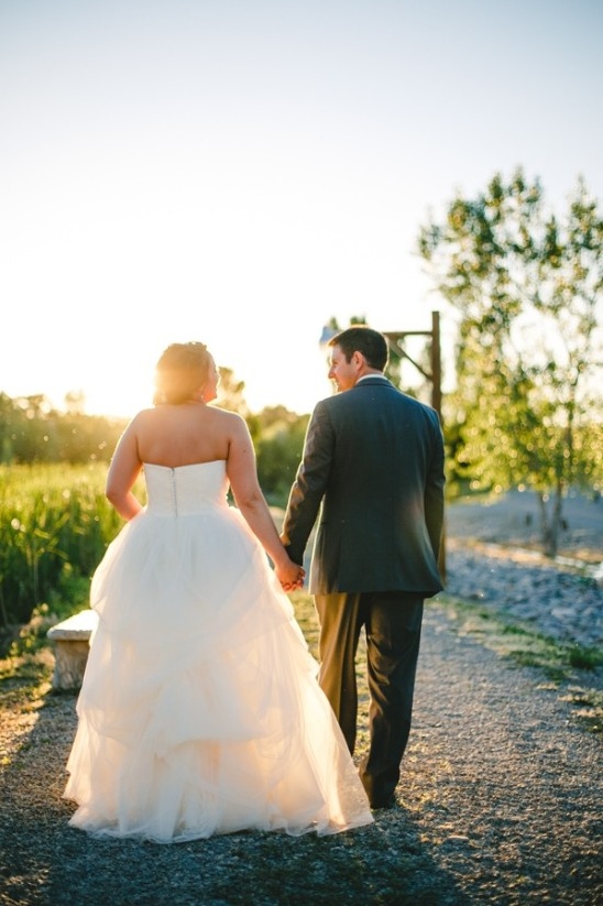 Bride and groom walking handinhand at sunset