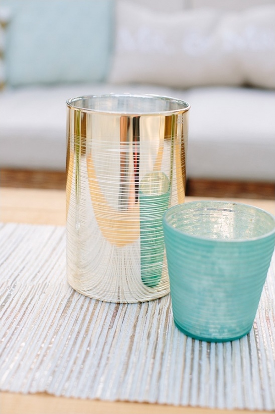 Silver and teal candle holders on a textured runner
