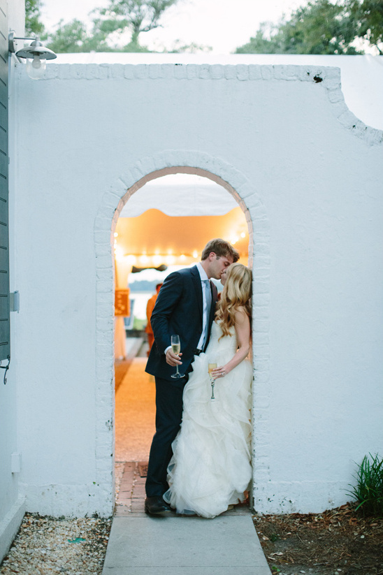 Bride and groom share a kiss at their wedding reception