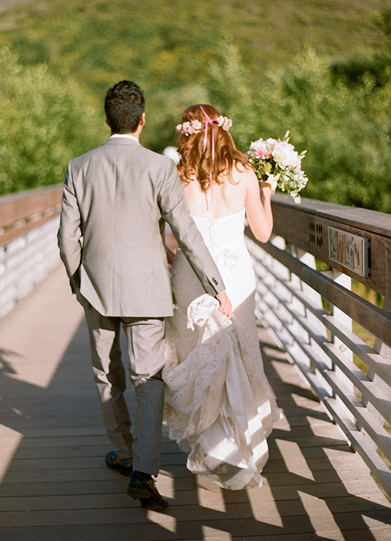 Bride and groom walking on a wooden bridge on their wedding day