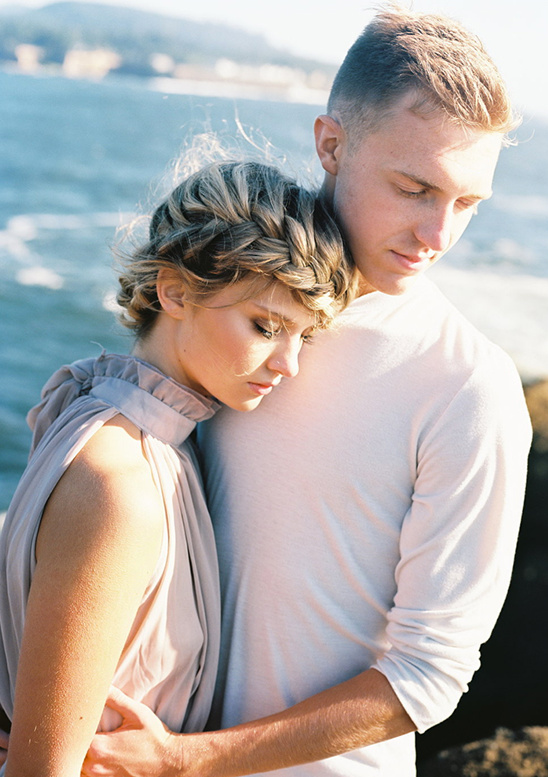 Loving couple embracing by the ocean on their wedding day