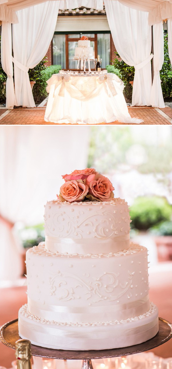 Elegant three tiered wedding cake with rose accents stands ready
