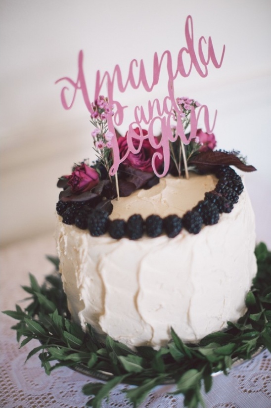 berry and floral topped cake with name cake topper