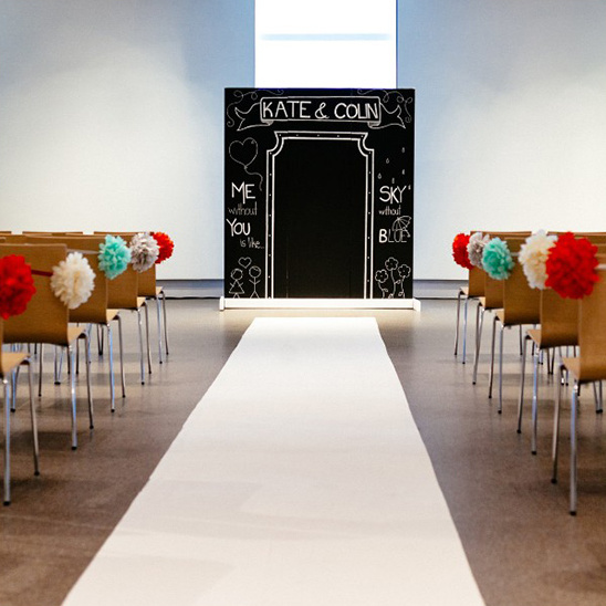 Wedding ceremony aisle with chalkboard backdrop and decorations