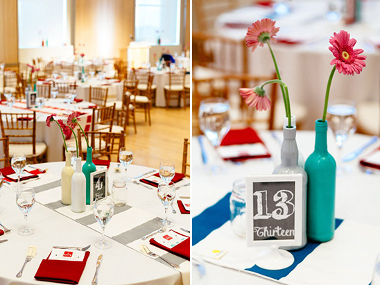 Wedding reception tables decorated with flowers in painted bottles