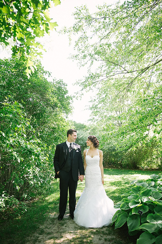 Beautiful bride and groom holding hands in a sunny garden