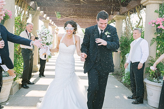 Bride and groom walk through confetti at a beautiful wedding