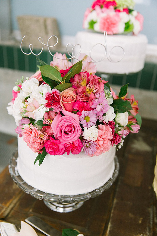 Wedding cake decorated with pink flowers and we do topper