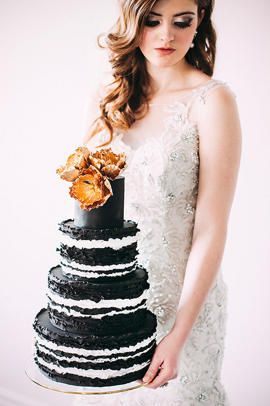 Bride holding elegant black and white wedding cake