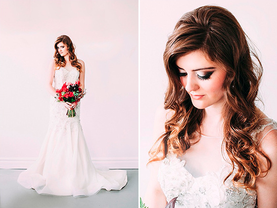 Stunning bride in lace wedding gown with red bouquet