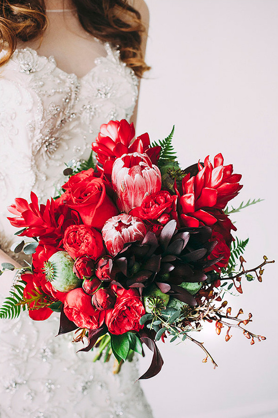 Stunning red wedding bouquet with proteas and roses
