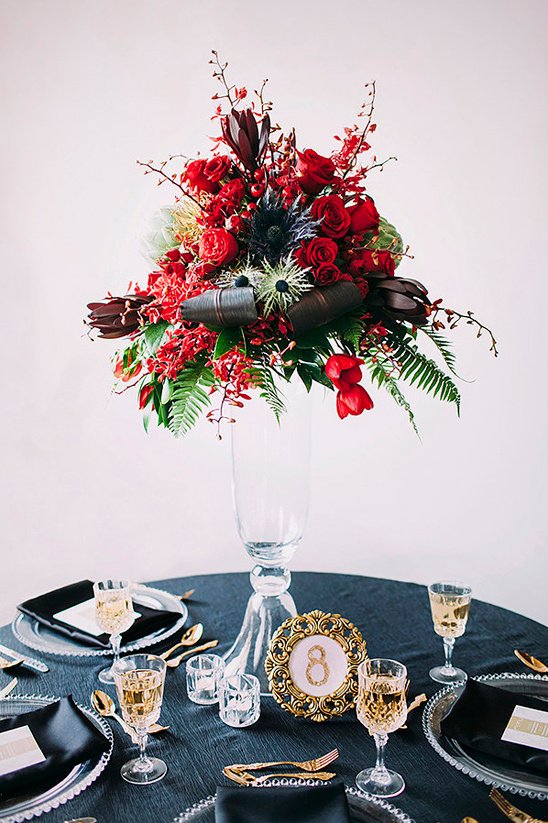 Elegant wedding table setting with red floral centerpiece