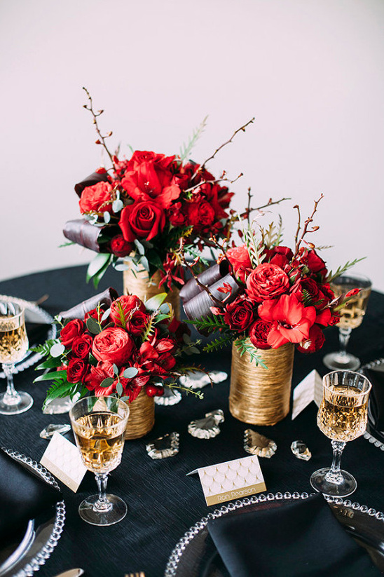 Elegant table setting with red floral centerpieces and champagne