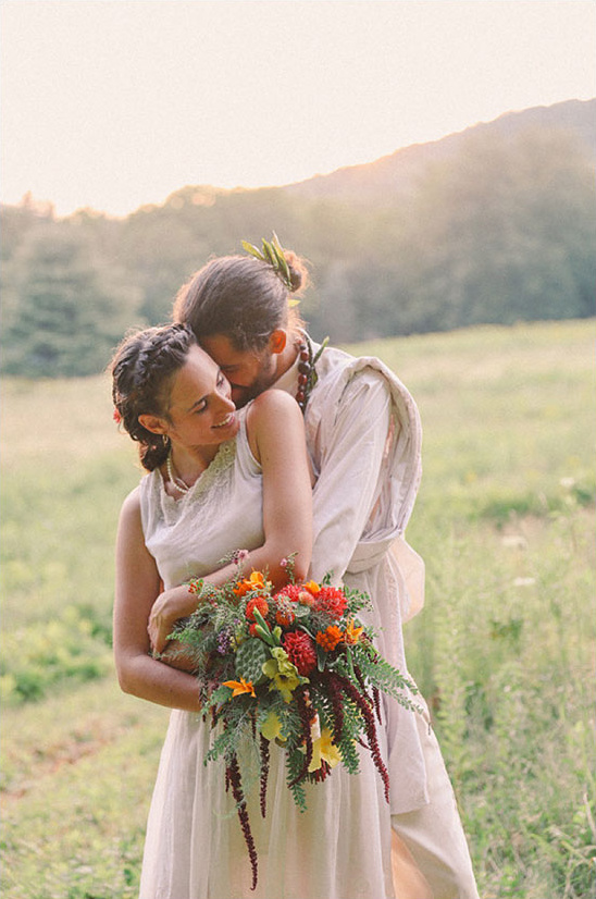 Happy couple embracing, holding vibrant wedding bouquet