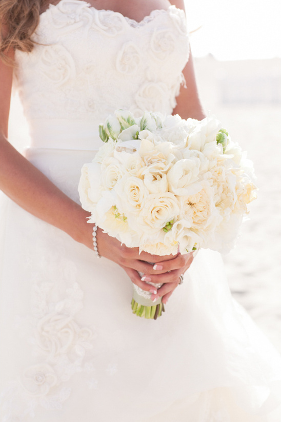 Bride holding a beautiful white rose wedding bouquet
