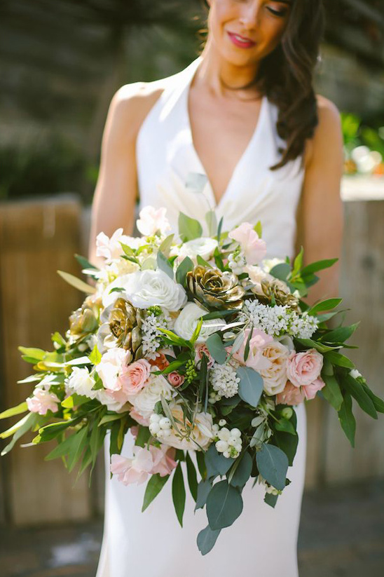 Bride holding elegant blush pink and gold wedding bouquet