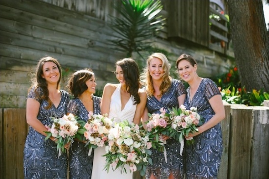 Smiling bridesmaids in sequined dresses with bouquets