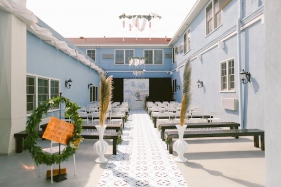 Outdoor wedding ceremony aisle with white chairs and floral decor