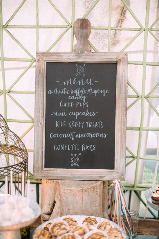 Chalkboard menu sign with delicious desserts at a rustic event