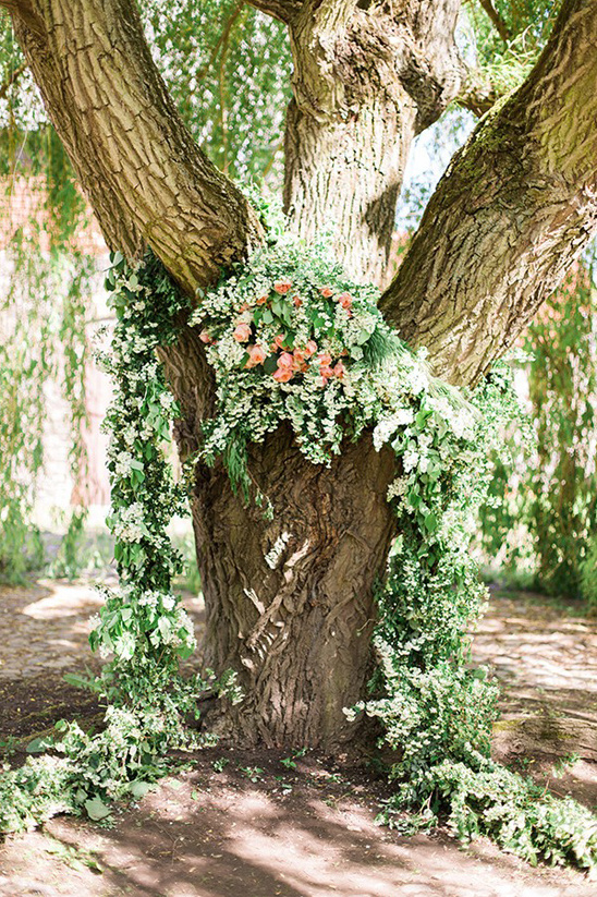 A tree decorated with flowers for a beautiful outdoor event