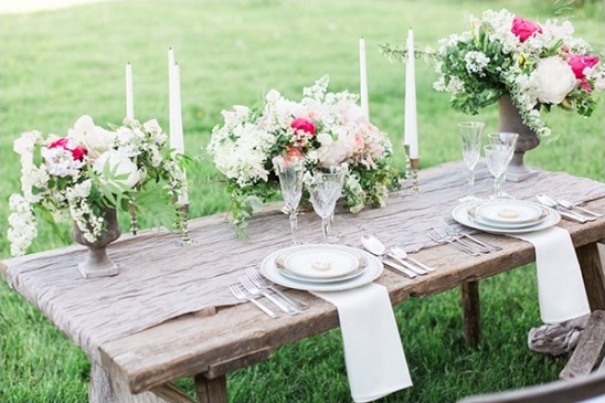 Rustic outdoor wedding table setting with floral arrangements