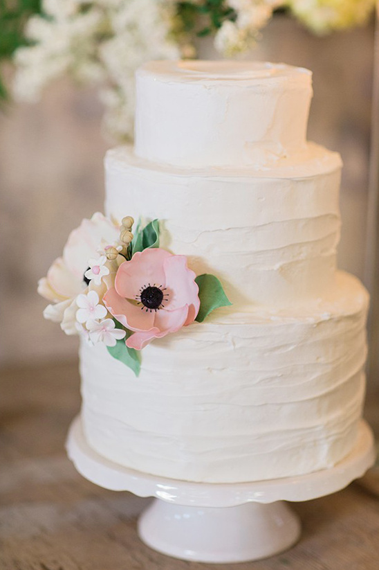 Elegant white wedding cake decorated with pink flowers