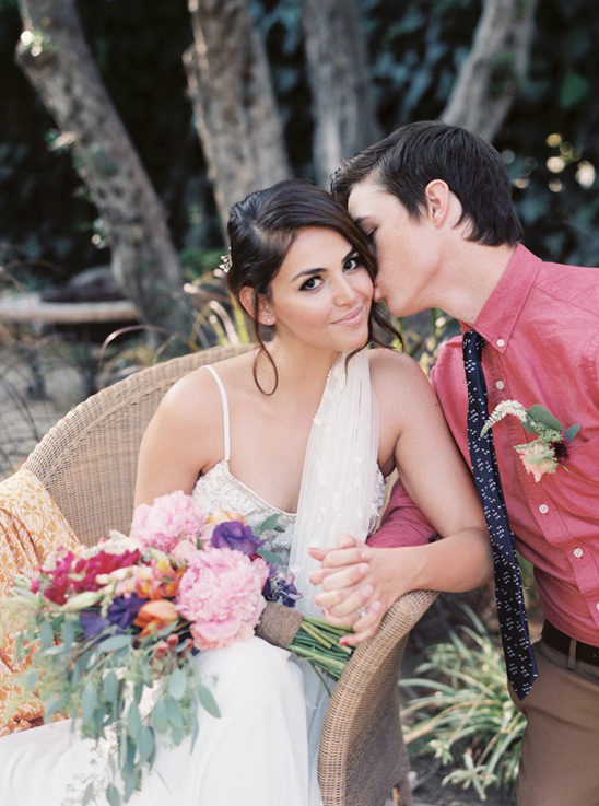 Affectionate newly wed couple sharing a kiss during outdoor ceremony