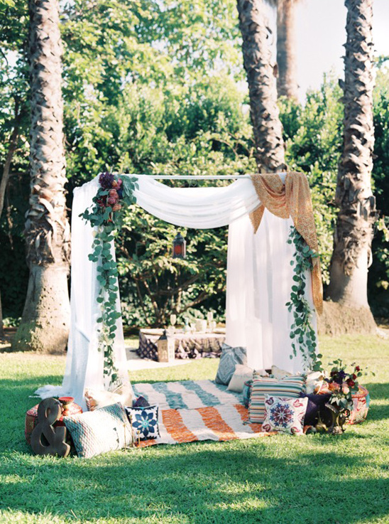 Bohemian picnic setting in the park with pillows and decoration