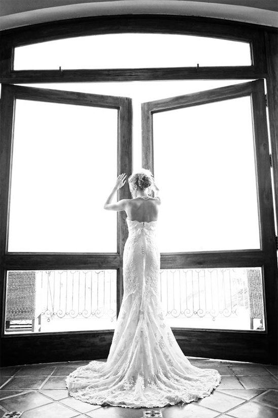 Bride in wedding dress by window