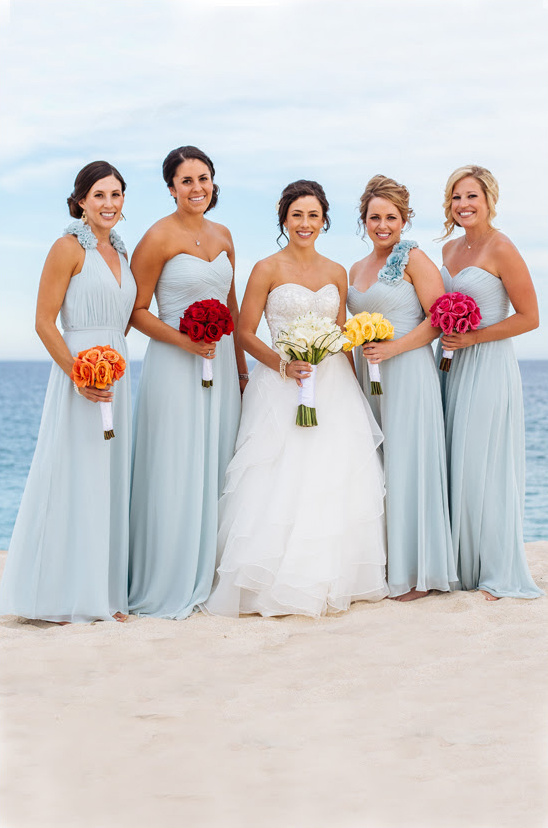 Bride with bridesmaids on beach in light blue dresses