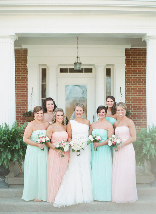 Bride and bridesmaids in pastel gowns posing outside