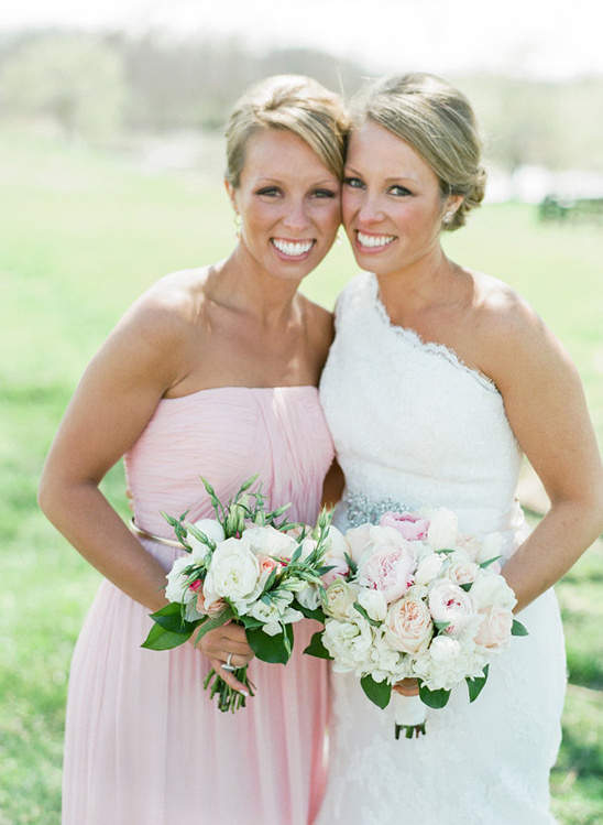 Smiling bridesmaids in pink and white dresses with bouquets