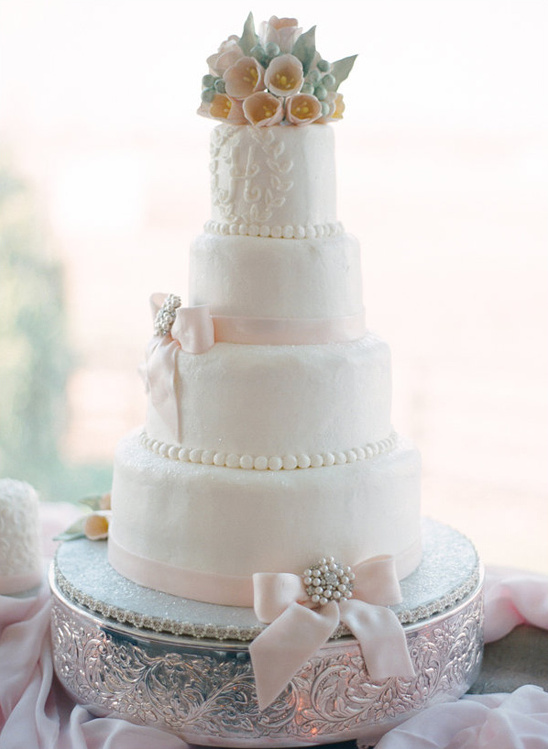 Elegant five-tiered wedding cake decorated with sugar flowers and bows