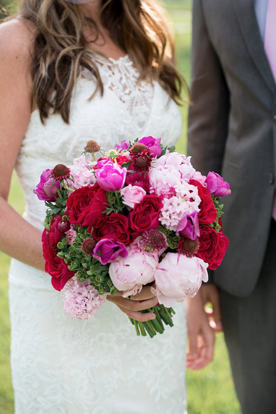 Bride holding a beautiful pink and red wedding bouquet