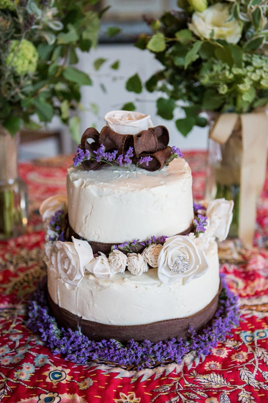 Two-tier wedding cake with lavender and white flower accents