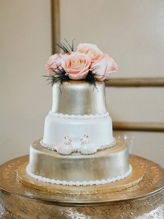 gold and white rose topped wedding cake