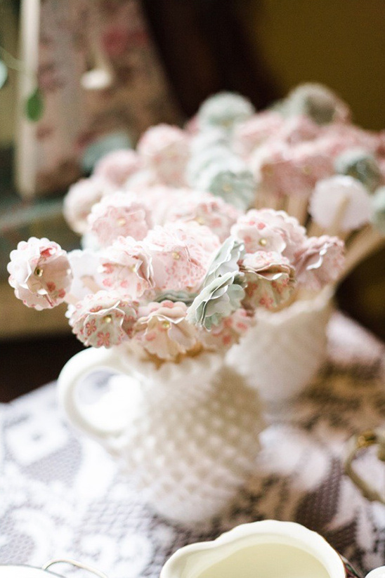 A bouquet of delicate pink and white paper flowers in a vintage white pitcher