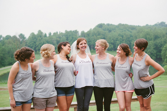 Happy bride poses with bridesmaids in matching shirts