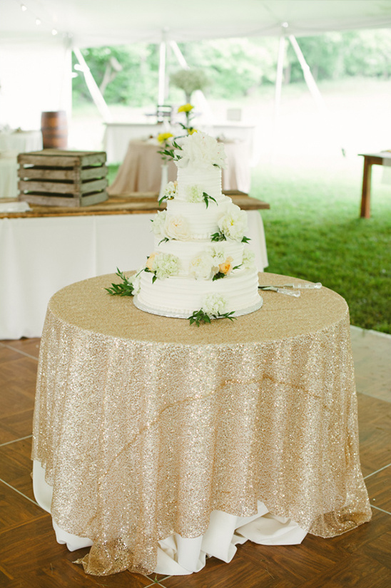 Elegant white wedding cake on a sparkly gold table