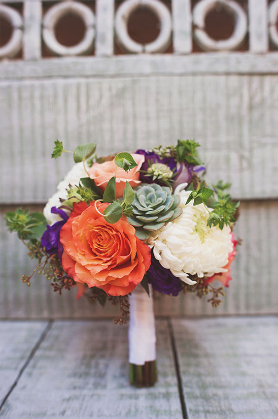 Vibrant coral rose wedding bouquet with succulents