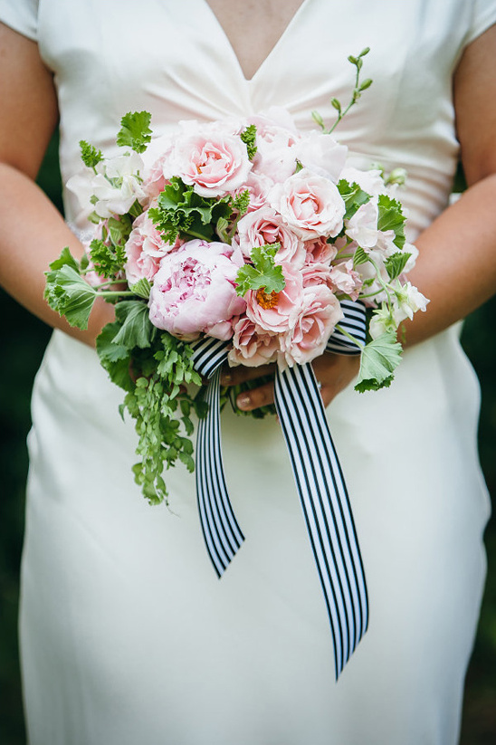 pink bouquet tied up with a black and white ribbon